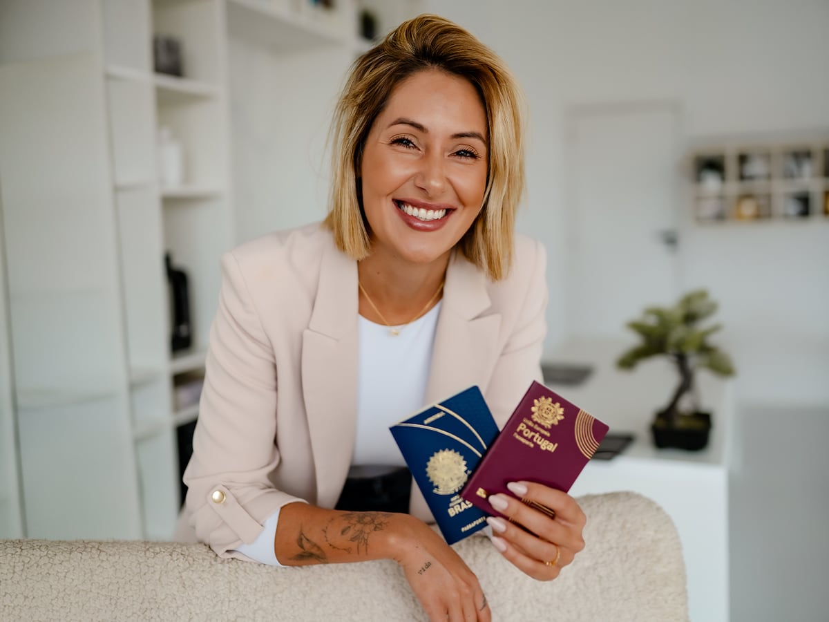 Carolina Vogels segurando os passaportes brasileiro e português
